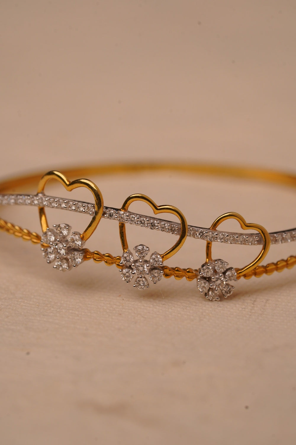 Gold bracelet displayed on warm fabric