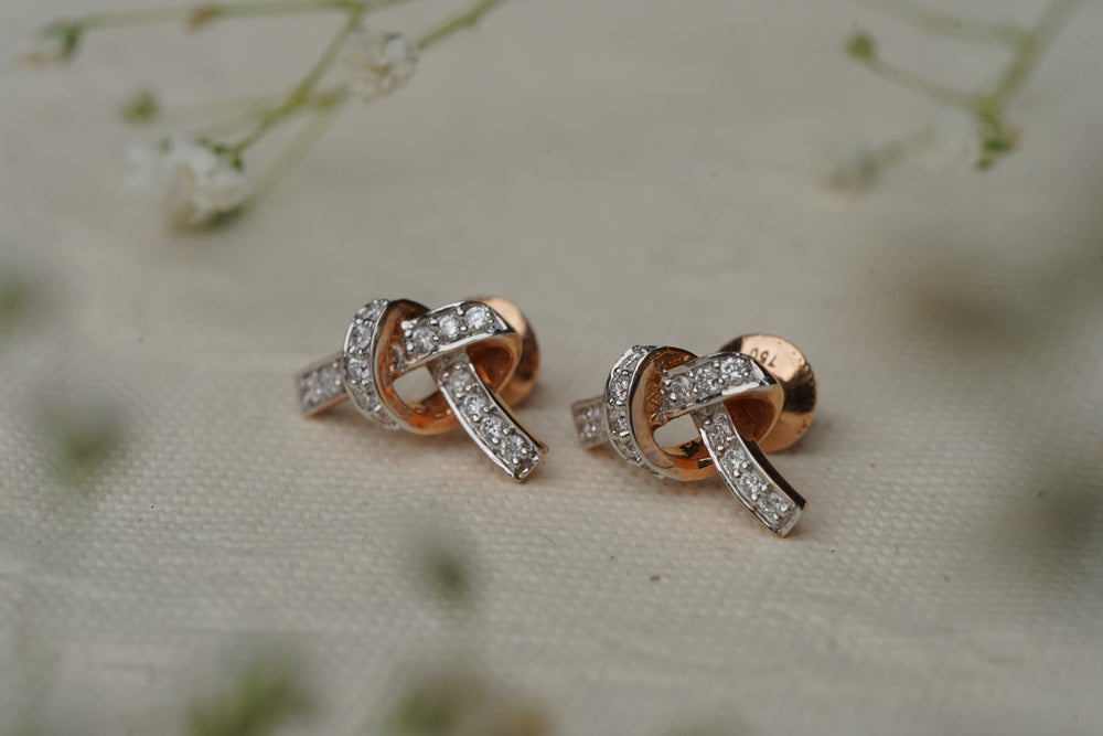 Compact gold eartops on a neutral backdrop